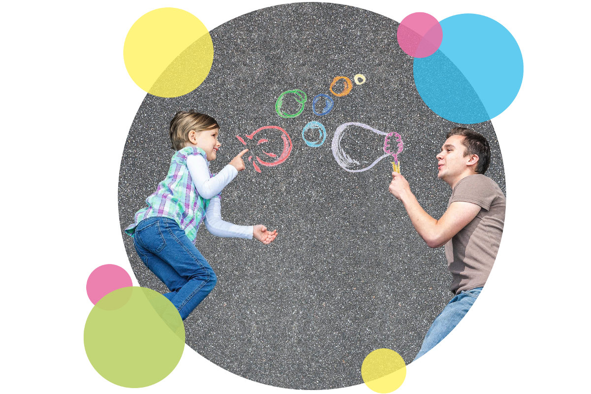 Kind und Erzieher spielen mit Seifenblasen
